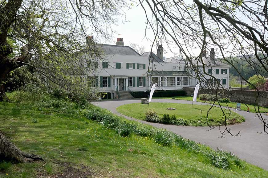 The white exterior and green shutters of Preston Manor house in Brighton