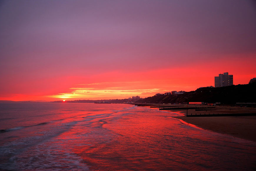 A vibrant sunset over the beach in Bournemouth, a coastal town in Dorset, England.