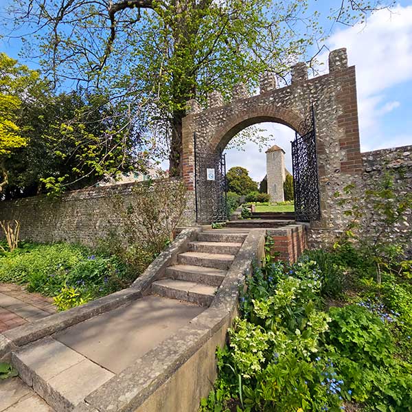 Walled garden Preston Manor, Brighton showing entrance steps and St Peter's Church through the entrance arch