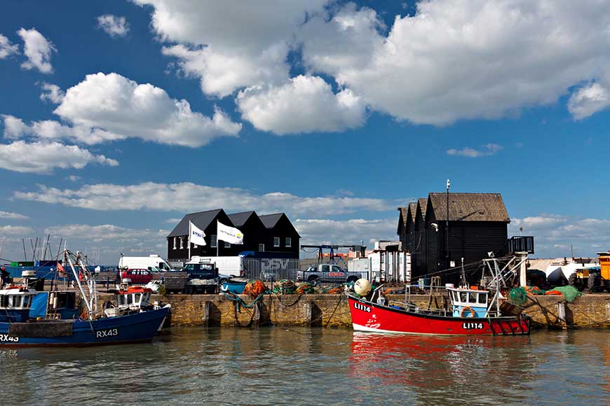 One blue and one red fishing boat moored in Whitstable harbour