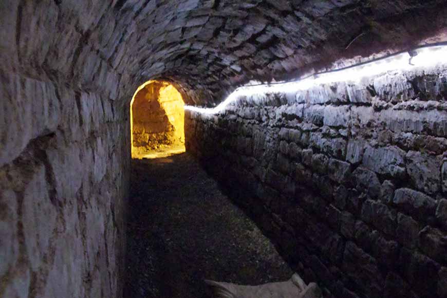 Narrow, dark stone tunnel part of Exeter's Underground Passages
