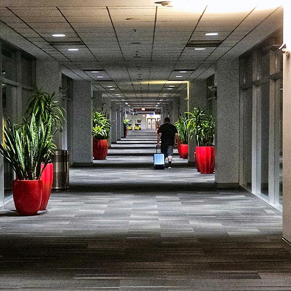 Man pulling a suitcase down a dimly lit corridor in Philadelphia Airport, USA