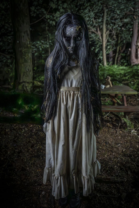 Dark Hollow Girl standing in woods at Alton Towers