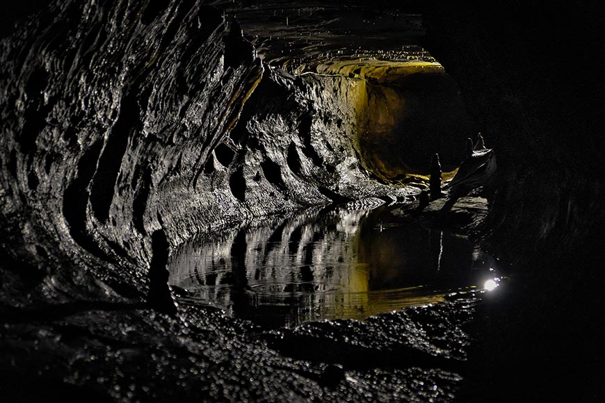 Interior of limestone cave showing rock formations and pool at Ingleborough Cave Yorkshire UK