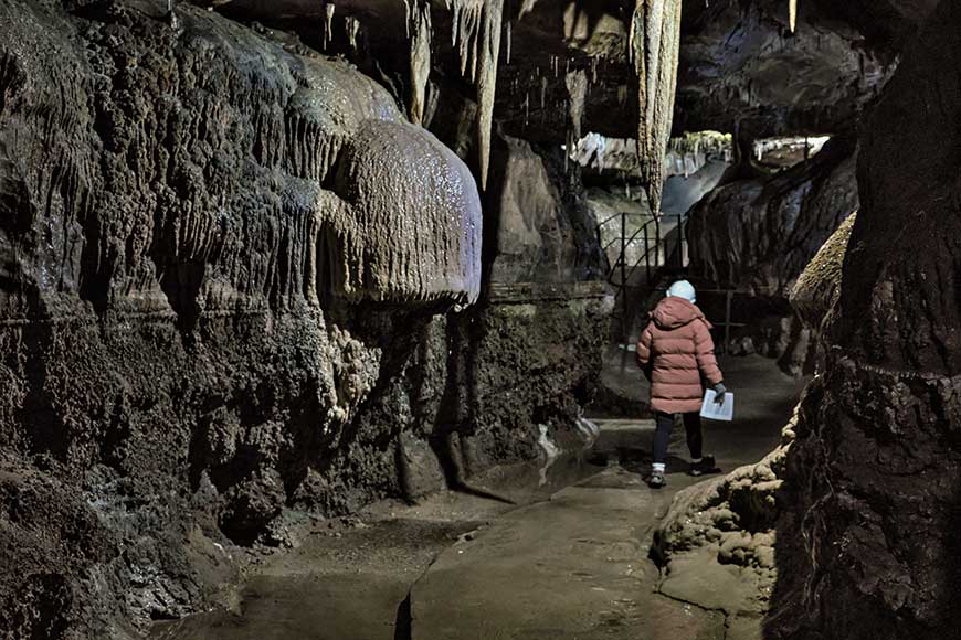 Woman on the cave on a self guided tour at Ingleborough Cave Yorkshire UK