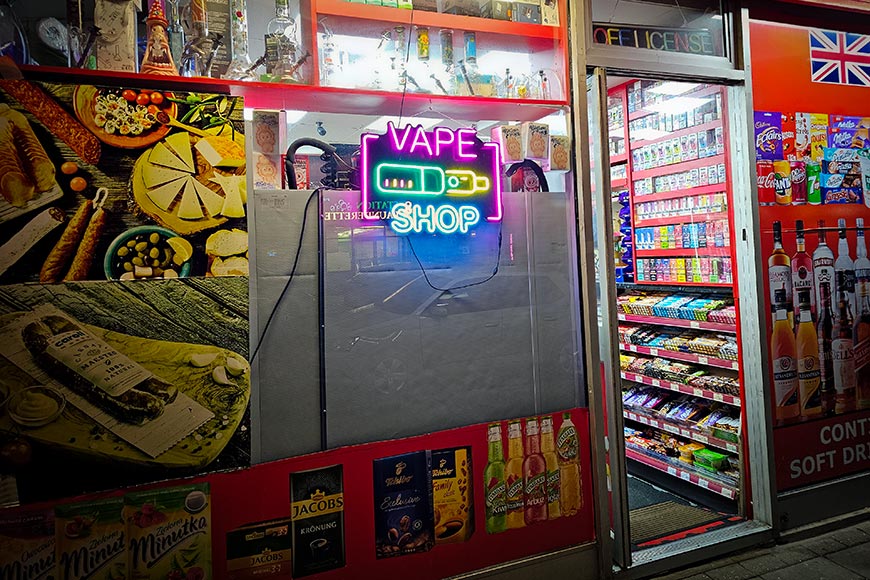 Neon lit Vape Shop sign and off-licence entrance