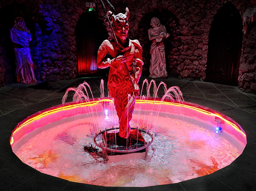 Pluto in the Underworld grotto featuring the red-lit devil fountain inside The Forbidden Corner in North Yorkshire, England