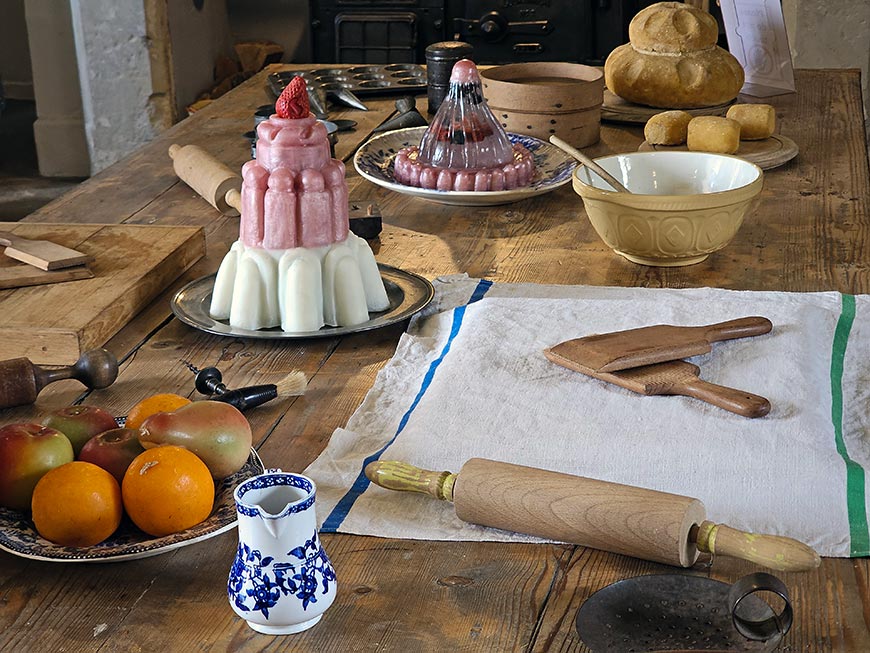 Wooden chopping blocks, rolling pins, and baked items that recreate the bustling atmosphere of a Victorian kitchen at Penshurst Place